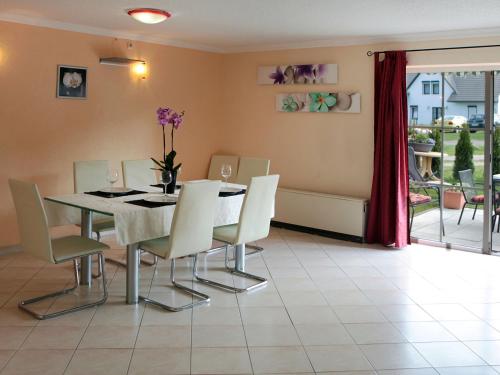 VerchenHoliday Home Ferienpark Verchen-3 by Interhome的一间带桌子和白色椅子的用餐室