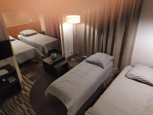 巴黎Le Jourdain的酒店客房,设有两张床和一盏灯