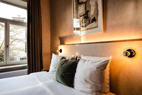 布鲁日莫里斯先生酒店的一间卧室配有带白色床单和枕头的床。