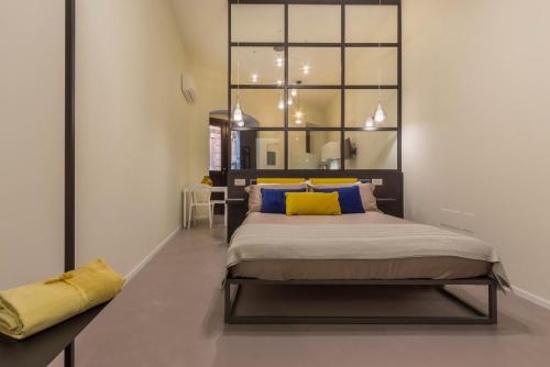 卡利亚里Suite Cagliari -97-的一间卧室配有一张带黄色枕头的大床