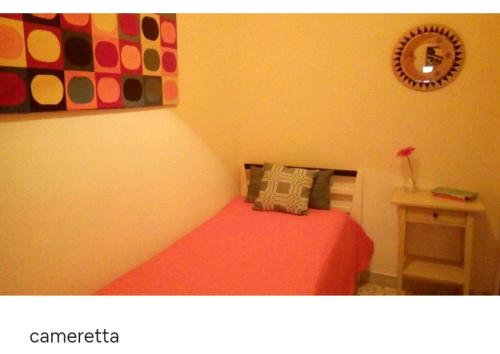 吉诺萨滨海CASA ADA的卧室配有红色的床和墙上的时钟