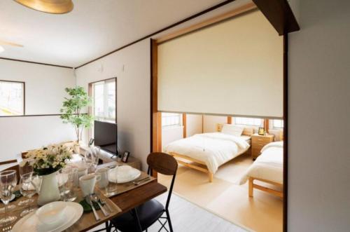 淡路ANJIN STAY AWAJI - Vacation STAY 83766的客厅配有两张床和一张餐桌