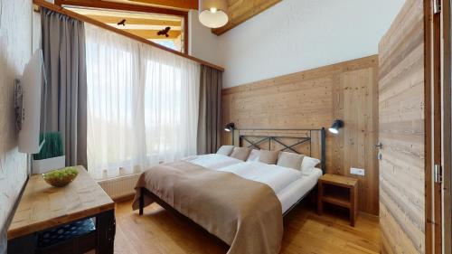 迪马诺卡多林纳Apartmány iziJasná的一间卧室设有一张床和木墙