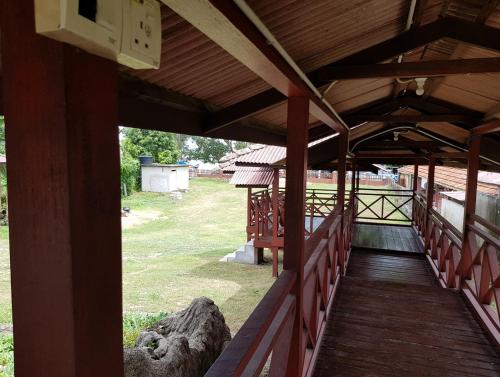 彭佳兰巴拉海滩Kampong Style Homestay Pengkalan Balak - Sea View的一座带木人行道的建筑的门廊