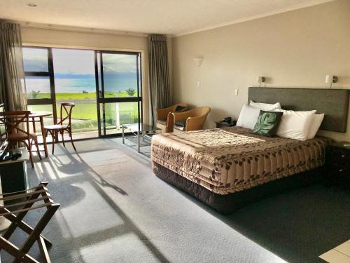 纳皮尔Harbour View Seaside Accommodation Napier的酒店客房设有一张床和一个阳台。