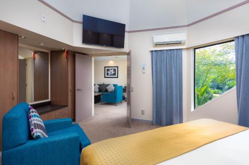 奥克兰奥克兰机场智选假日酒店的一间卧室配有一张床、一张沙发和一台电视。