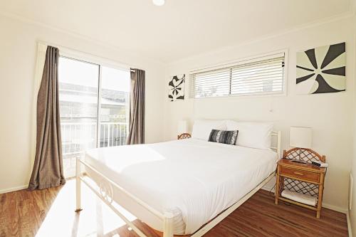 梅林布拉海滩拾遗公寓 - 可携带宠物的白色的卧室设有一张大床和一个窗户