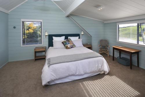 欧尼罗亚Noll View的一间卧室配有一张床、一张书桌和两个窗户。