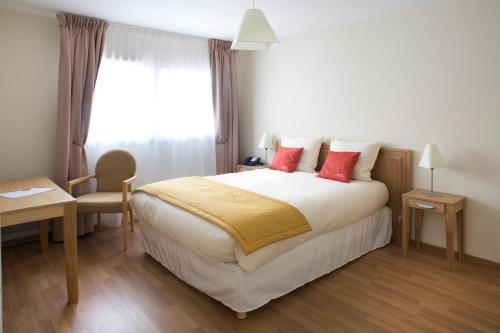 奥尔泰兹Domitys Les Clés d'Or的一间卧室配有一张带红色枕头的大床