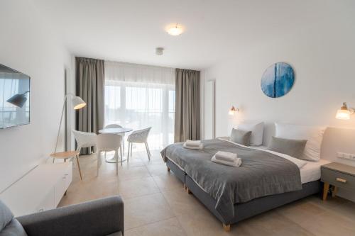 米兹多洛杰Aquamarina Prima Studio with Sea View by Renters的卧室配有一张床和一张桌子及椅子