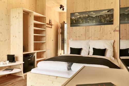基弗斯费尔登Water, Ski & Mountain Lodge的卧室配有一张床铺,位于带木墙的房间内