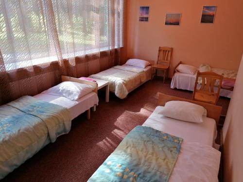 拉脱维亚明霍泽娜武达酒店的一组床位,位于一个窗口的房间