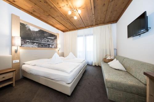 欧缇莫Hotel Alpenhof的酒店客房,配有床和沙发