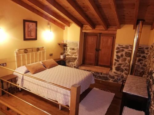Santa María乡间塔楼公寓酒店的一间带一张床的卧室,位于带木制天花板的房间内