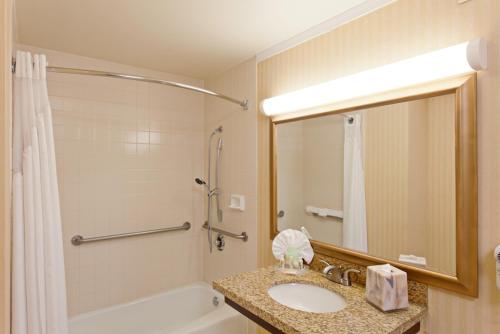 长滩长滩机场假日酒店的一间带水槽、浴缸和淋浴的浴室