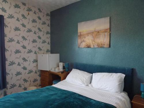 大雅茅斯契克斯酒店的卧室配有一张床,墙上挂着一幅画