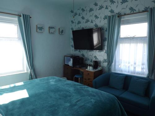 大雅茅斯契克斯酒店的一间卧室配有一张床、一台电视和一张沙发