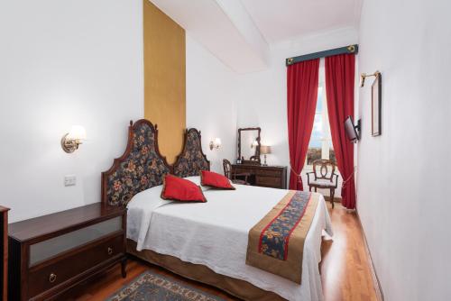 瓦莱塔卡斯蒂利亚酒店的一间卧室配有一张床、一张书桌和一个窗户。
