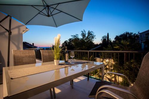 茨里克韦尼察Apartments San Leopoldo的阳台配有桌椅和遮阳伞