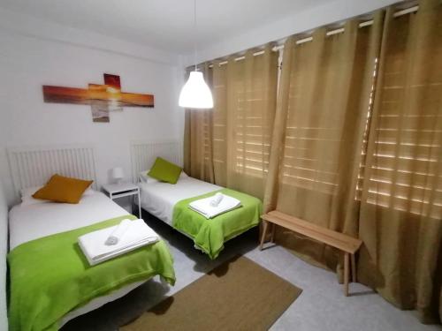 马拉加Del Parque Flats - Guadalmar - Beach & Relax的配有绿床单的客房内的两张床