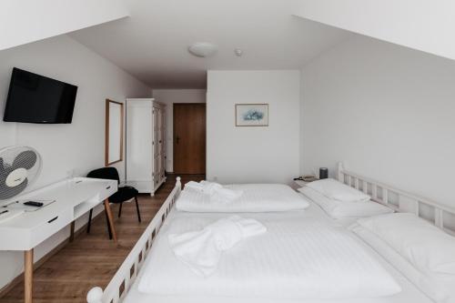 滨湖默尔比施莫比斯契尔霍夫酒店的客房设有两张床和一台墙上的电视。