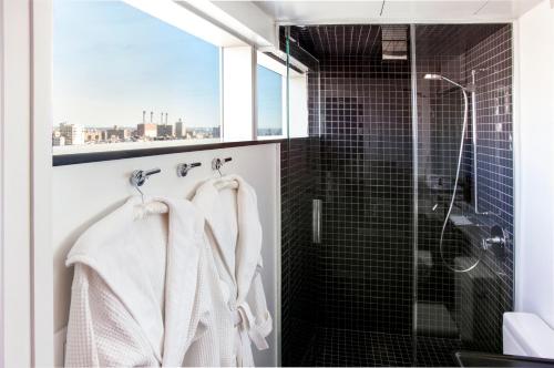 纽约东乡村设计酒店的一间带白色毛巾和淋浴的浴室