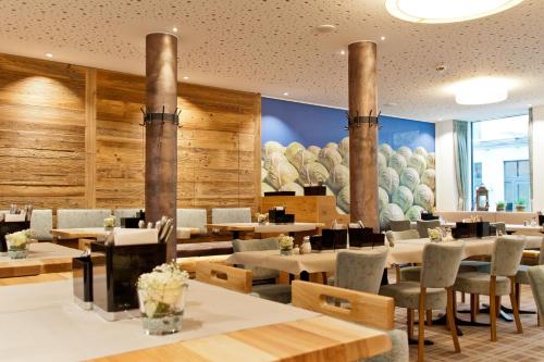 伊斯马宁泽波斯特酒店的餐厅拥有木墙和桌椅
