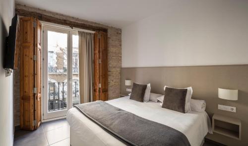 瓦伦西亚Mon Suites San Martin的一间卧室设有一张大床和一个大窗户