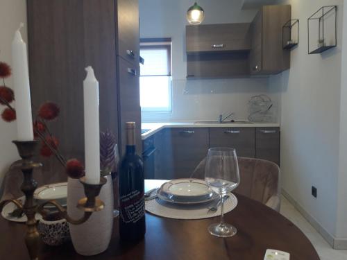 希贝尼克Apartmani Ponistra的餐桌,配有一瓶葡萄酒和玻璃杯