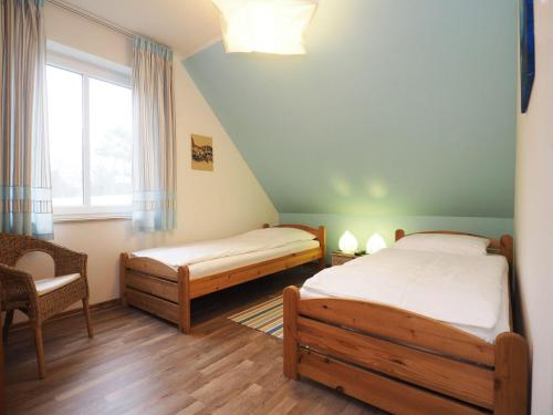 科尔斯万特Ferienhaus Sonneninsel 5c的一间卧室设有两张床、一把椅子和一个窗户。