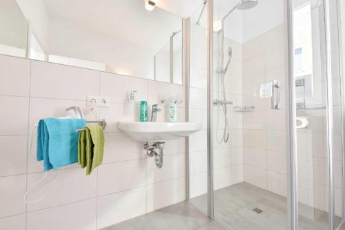 KamminkeKleines Ferienhaus Kuschelnest的白色的浴室设有水槽和淋浴。