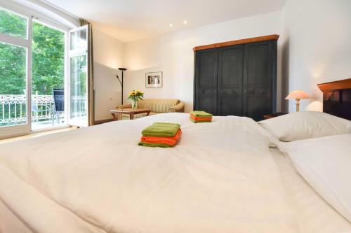 黑灵斯多夫Villa Hohe Düne 06的一张白色大床,上面有两条绿色毛巾