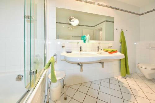 黑灵斯多夫Villa Hohe Düne 06的一间带水槽、卫生间和镜子的浴室