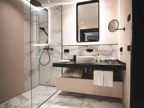 施托尔贝格哈尔茨Hotel & Spa Suiten FreiWerk的带淋浴、盥洗盆和镜子的浴室