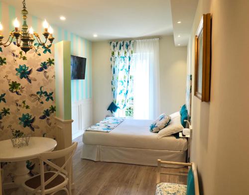 贝拉吉奥豪斯百思酒店的一间卧室配有一张床、一张桌子和一个窗户。