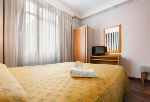 巴塞罗那里昂酒店的酒店客房,配有床和电视