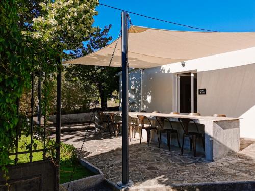 科尔特Maison San Giovanni的一个带桌椅的白色遮阳伞下庭院