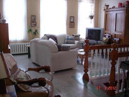 Saint-Luc-de-Vincennes姐妹别墅旅馆的客厅配有沙发、椅子和电视
