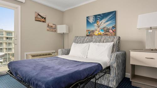 威尔伍德克拉斯特冒险家海滨酒店的配有一张床和一把椅子的酒店客房