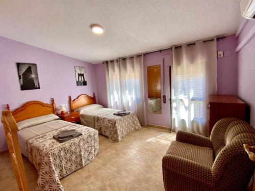 Casas del MonteAPARTAMENTO TURISTICO NAVALINDA的酒店客房,配有两张床和椅子