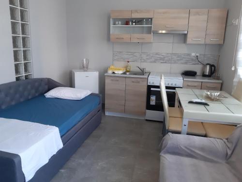 内亚卡瓦里Soula's Sunshine Blue Apartment的小房间设有床和厨房