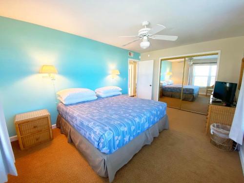 圣徒皮特海滩海畔卡米洛特酒店的一间卧室设有一张床和蓝色的墙壁