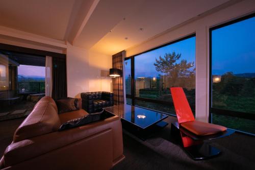 京都Riverte Kyoto Kamogawa的带沙发和椅子的客厅以及大窗户。