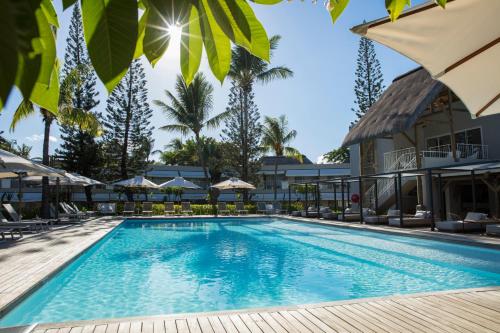 塔马兰沃兰达塔玛林Spa酒店的度假村的游泳池,配有椅子和遮阳伞