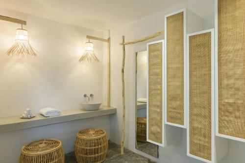 塔马兰沃兰达塔玛林Spa酒店的浴室设有水槽、两面镜子和柳条凳