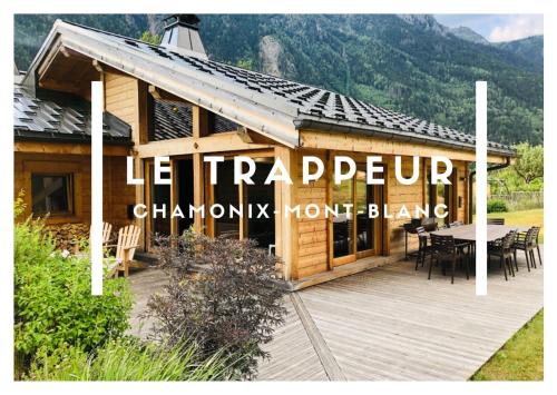 夏蒙尼-勃朗峰Grand chalet Le Trappeur - Chamonix的一座带木甲板和桌子的建筑