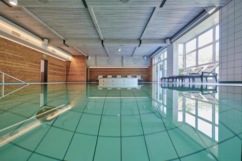 哈尔布莱希本瓦尔德西酒店的一座建筑物内蓝色地板的游泳池