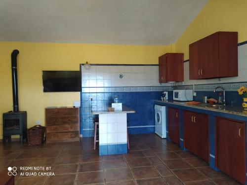 El Pinar del HierroCasa Rural El Pajar的厨房拥有蓝色和黄色的墙壁,配有炉灶