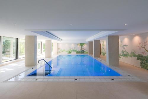 海尔布隆海尔布隆英赛尔酒店的大楼内一个蓝色的大型游泳池