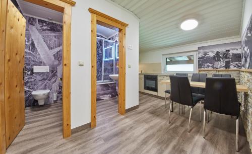 萨尔巴赫Ski & Bike Appartements Forsthaus的厨房以及带桌椅的用餐室。